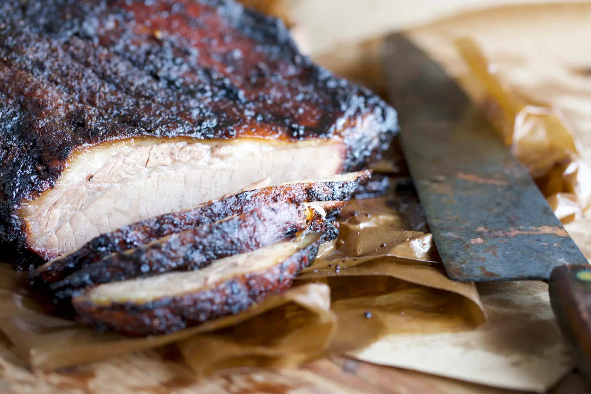 sliced brisket on a cutting board with a knife