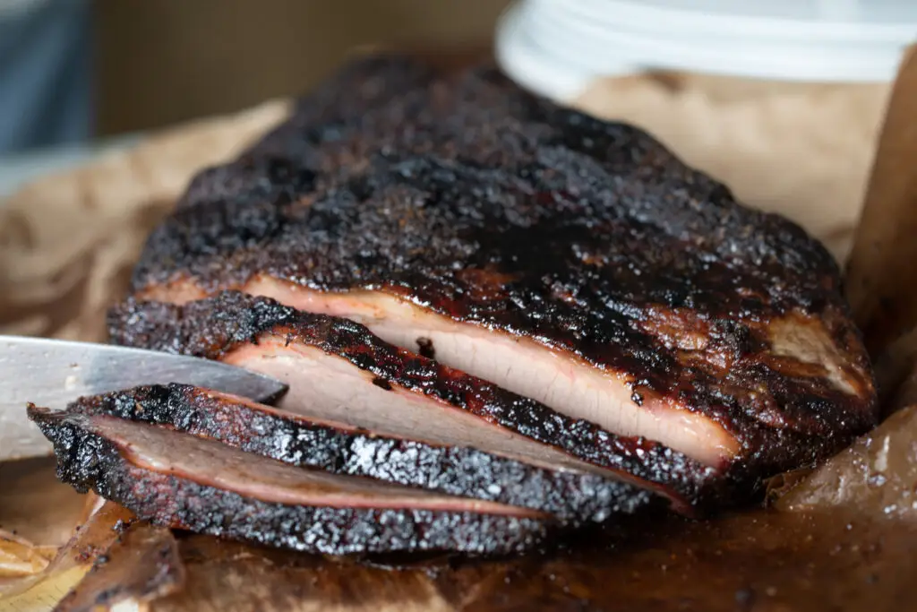 sliced brisket with a light pink smoke ring. Texas Style Barbecue
