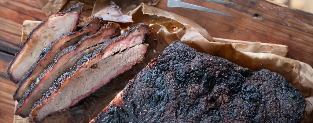 Sliced smoked brisket on a table. Texas Style Barbecue
